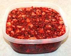 a plastic container filled with cranberry sauce on top of a table