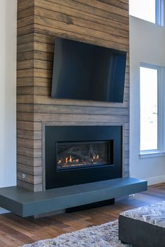 a fireplace with a flat screen tv mounted on it's wall above the fire place