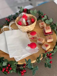 a wooden tray topped with lots of red and white decorations next to a basket filled with candy