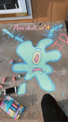 someone is drawing on the sidewalk with chalk and crayons