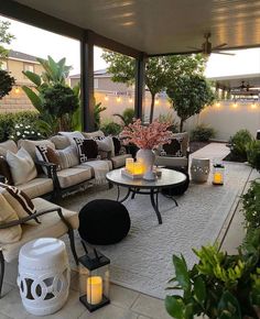 an outdoor living area with couches, tables and candles