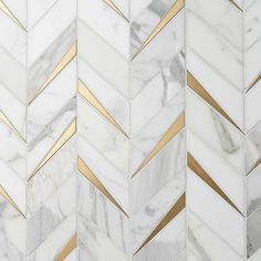 white and gold herringbone marble tile with metallic lines on the edges, in an angled pattern