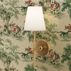 a lamp that is next to a wall with horses on it and a white shade