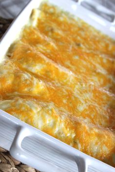 a casserole dish with cheese in it sitting on a wicker tablecloth