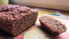 two pieces of brown bread sitting on top of a colorful plate next to a cup