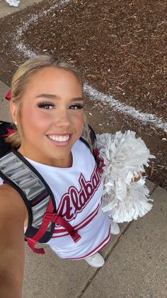 a cheerleader is posing for the camera with her pom poms in hand