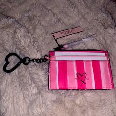 a pink card case with a heart on the front and a chain attached to it