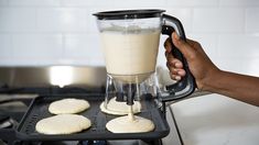 a person is using a blender to make cookies on the stove top with dough in front of them