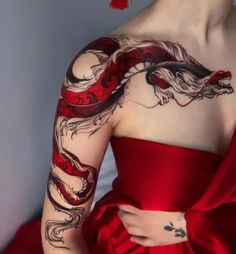 a woman in a red dress with tattoos on her arm