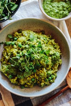 a bowl filled with green food next to two bowls of pesto and pea sauce