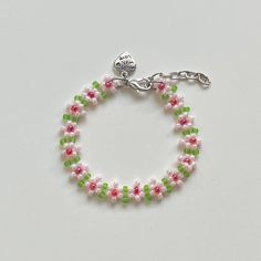 "Handmade Beaded Bracelet ✿ Made with glass seed beads and metal accents ✿ Pastel pink, red, and matte lime ✿ The bracelet has 1.5\" of extension chain" Handmade Red Bracelets For Spring, Pink Tiny Beads Jewelry For Spring, Pink Adjustable Beaded Chain Bracelets, Adjustable Pink Beaded Chain Bracelets, Green Beaded Flower Crystal Bracelet, Green Beaded Flower Friendship Bracelets, Pink Tiny Beads Bracelets For Spring, Adjustable Beaded Crystal Bracelet For Spring, Green Flower-shaped Bracelet With Tiny Beads