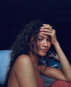 a black and white photo of a woman sitting on a couch with her hands in her hair