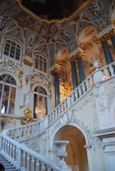 an ornate building with gold and white decorations on the walls, stairs and balconies