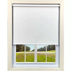 an open window with white roller shades on the windowsill and grass in front of it