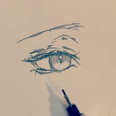 a pencil drawing of an eye with the iris drawn on paper, next to a marker