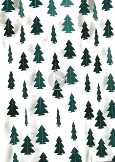 green christmas trees are hanging from strings on a white background with black and white wallpaper