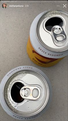 two soda cans sitting next to each other on a table