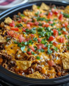 a black crock pot filled with nachos and cheese