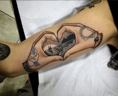 a person with a tattoo on their arm holding a heart