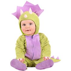 a baby wearing a green and purple dragon costume sitting on the ground with its legs crossed