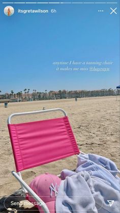 a pink beach chair sitting on top of a sandy beach