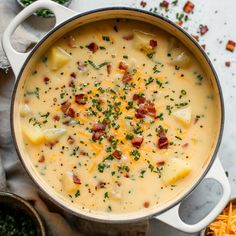 a pot filled with cheese and bacon soup on top of a white cloth next to other dishes