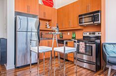 an apartment kitchen with stainless steel appliances and wood flooring is pictured in this image