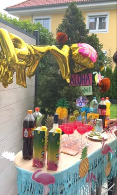 a table topped with lots of drinks and balloons