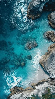 an aerial view of the ocean and rocks