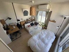 an aerial view of a living room with a bed, couch and desk in it