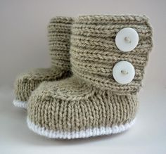 a pair of knitted baby booties with buttons on the front and back side