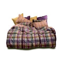 a bed with plaid sheets and pillows on it's headboard, in front of a white background