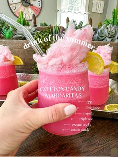 a person holding a pink cocktail in front of a mirror with the words cotton candy margaritas on it