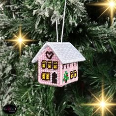 a pink house ornament hanging from a christmas tree