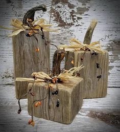 three wooden pumpkins decorated with fall decorations on top of each other and tied to wood planks