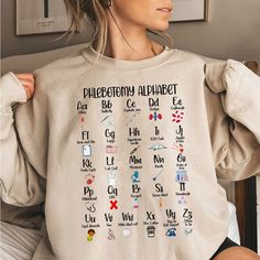 a woman wearing a sweatshirt with the alphabet on it