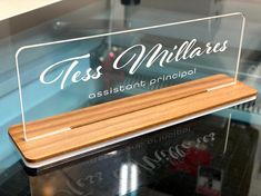 a glass sign that says tres milliares assistant principals on the front and side