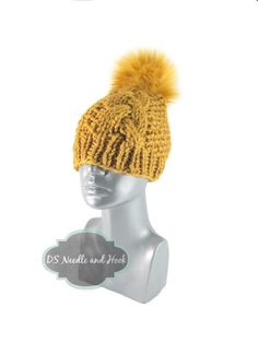 a knitted hat with a yellow pom - pom on the top and bottom