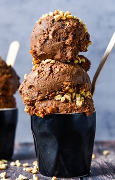 three ice cream cones stacked on top of each other with spoons sticking out of them