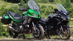 two motorcycles parked next to each other in front of a wooden fence and grassy area