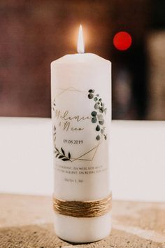 a white candle is sitting on a table