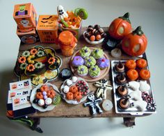 a wooden table topped with lots of halloween treats and candies on top of it