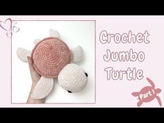 the crochet turtle is made from yarn and has two hands holding it up