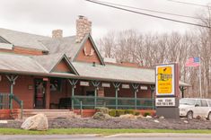 a car is parked in front of a red brick building with a sign that says the lodge on it