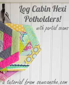 a close up of a quilt hanging on a wall with the words log cabin hexi potholders