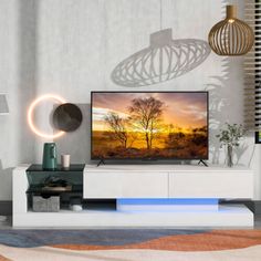 a flat screen tv sitting on top of a white entertainment center in a living room