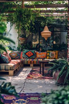 an outdoor living area with colorful cushions and plants