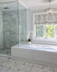 a bathroom with a tub, shower and window