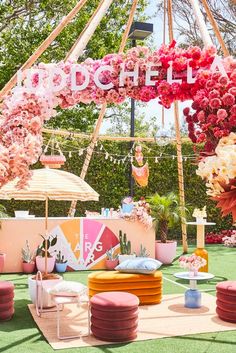 an outdoor party with pink and white decor, flowers and decorations on the table in front of a ferris wheel