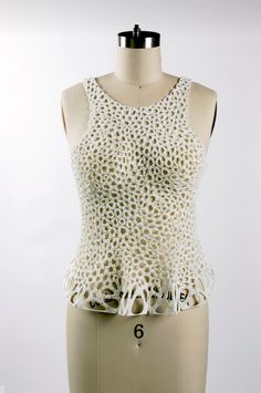 a mannequin wearing a white top with holes on it